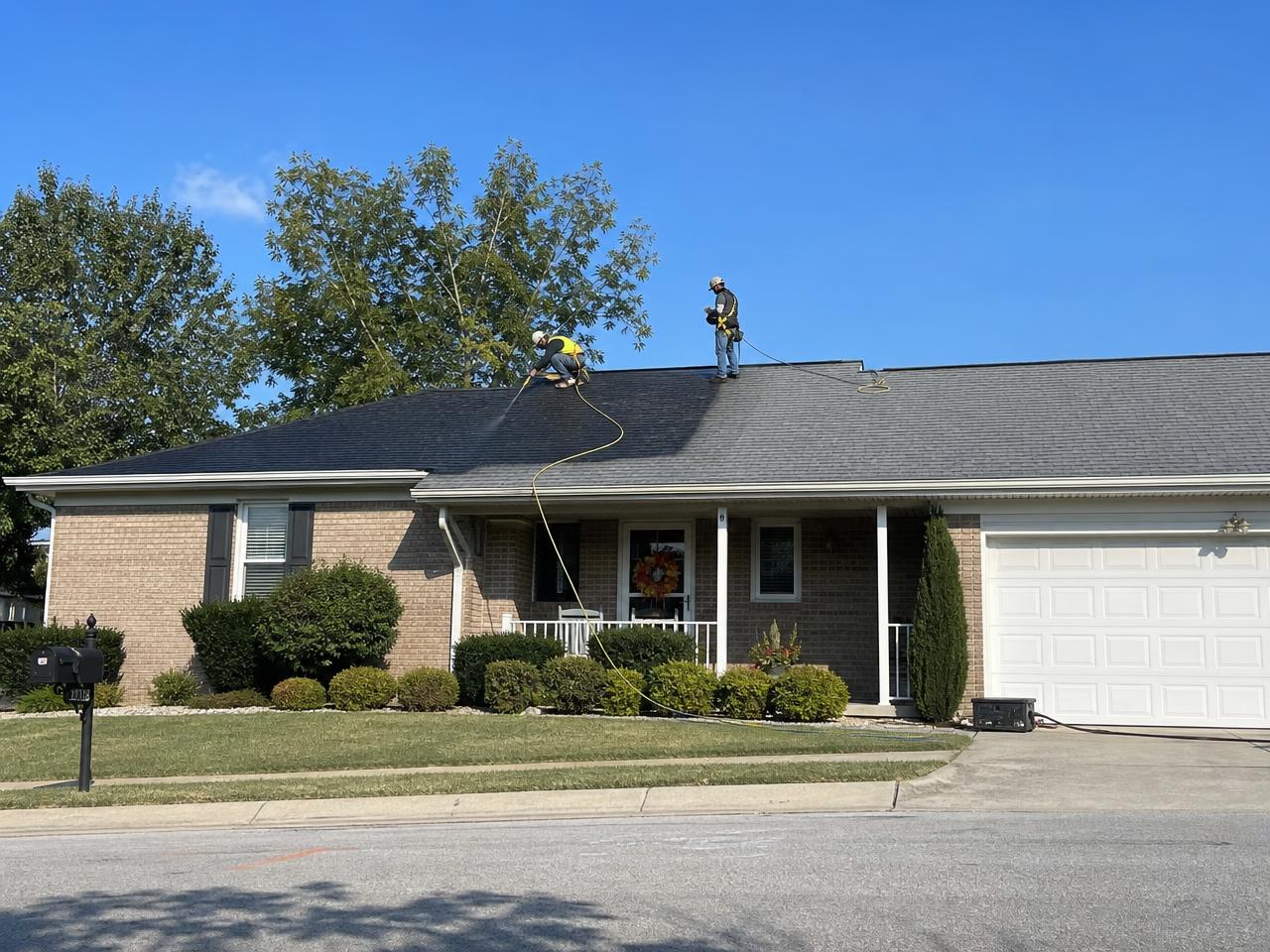 Roofing crew preparing a shingle roof for treatment